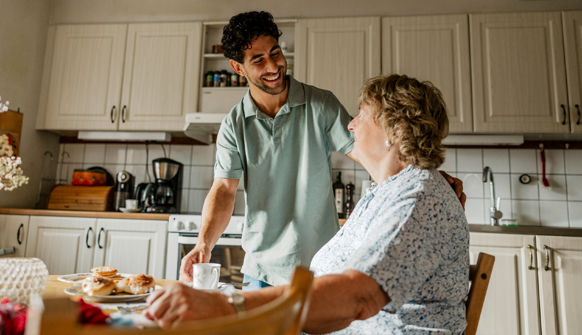 Adult son joining his mother at the breakfast table