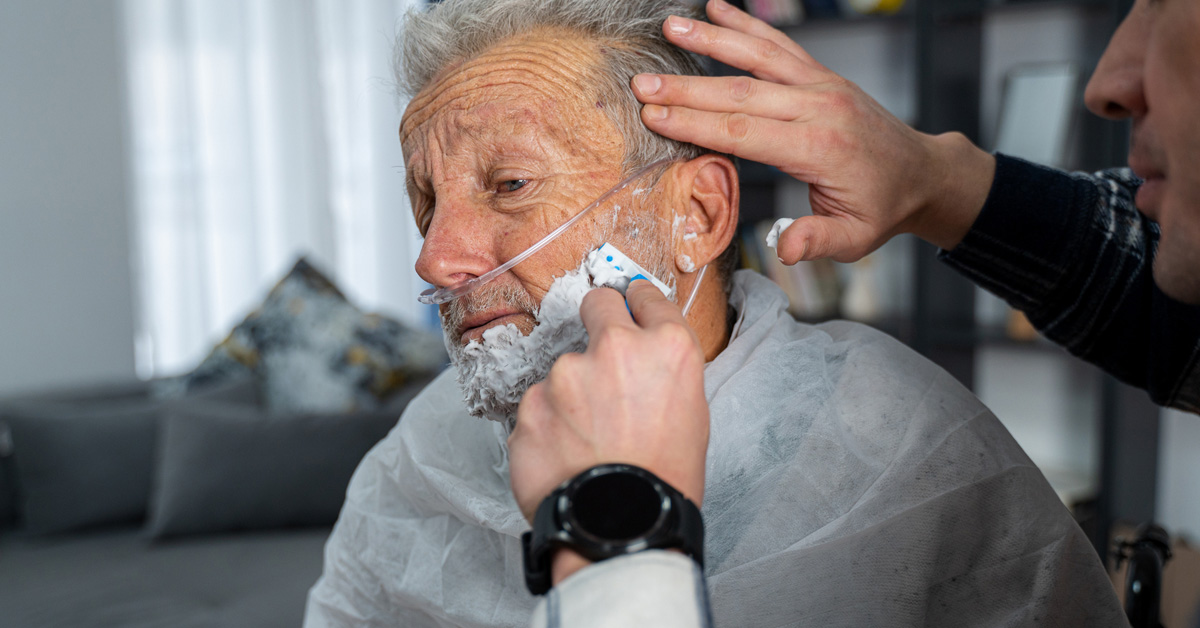 Son shaving father’s beard